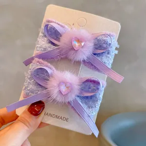 Close-up of purple mink fur bow hair clips with sparkling heart crystals for girls