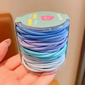Detailed view of assorted blue and purple elastic hair ties in round packaging