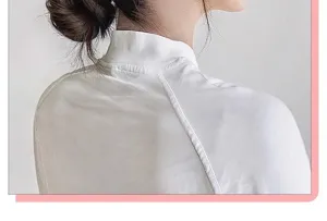 Detail shot of natural messy bun hairpiece on a woman wearing a white top accessory.