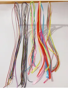 Vista dettagliata di varie corde colorate per trecce e nastri vivaci per capelli bimbe