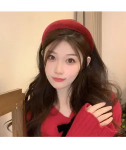 Close-up view of a high skull top retro red velvet padded headband worn by a model