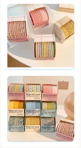 Detailed view of candy-colored braided hair ties in organized gift packaging.