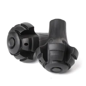 Detail view of black rubber trekking pole tips, torpedo shaped non-slip covers for hiking sticks.