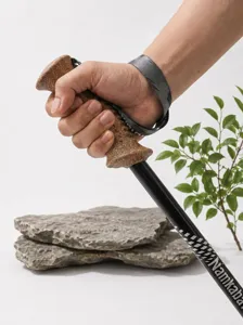 Primo piano dettagliato dell'impugnatura ergonomica in sughero e del cinturino da trekking.