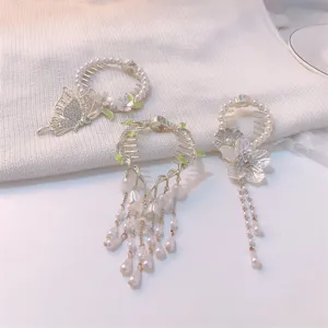 Detailed view of three antique style Lily of the Valley hair clips with pearl tassels