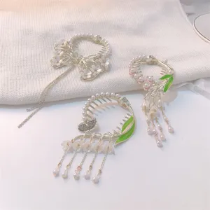Detailed view of three floral tassel hair clips with pearls and rhinestones.