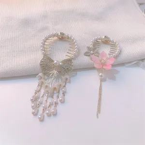 Close-up of elegant hair clips with lily of the valley tassels and pink flower design