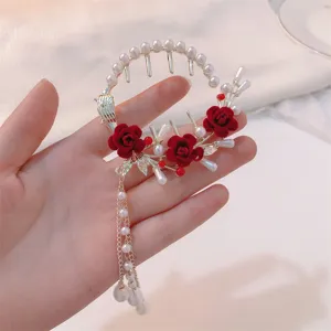 Detailed view of a vintage-style hair clip with red roses and pearl tassels.