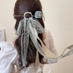 Detailed view of an elegant ancient-style hair pin with lace ribbons on long hair.