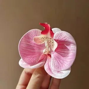 Close-up of pink orchid hair clip with pearl detail for forest style hairstyles