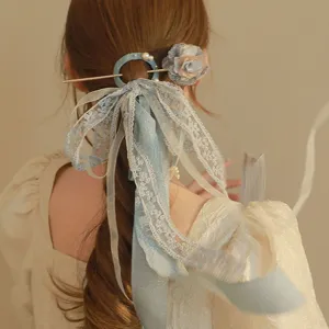 Detailed view of an elegant ancient style hairpin with blue lace ribbon and fabric flower
