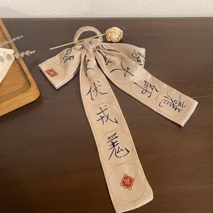 Close-up of elegant beige hair stick ribbon with Chinese calligraphy for Hanfu hair decor