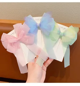 Detalle de tres pinzas para el pelo de mariposa estilo hada para niñas en rosa, azul y verde