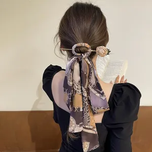 Close-up of elegant gold hairpin with long chain print ribbon scarf for bun hairstyles