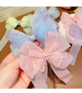 Primer plano de un pasador de pelo con lazo de mariposa de malla rosa bordado para niñas