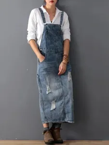 Dettaglio gonna salopette in denim strappato vintage, abito casual da donna moda.
