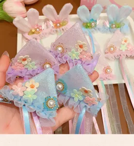 Close-up of children's rabbit ear hair clips with pastel flowers and long ribbons