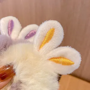 Detailed view of a cute plush bunny ear hair scrunchie with soft white faux fur texture