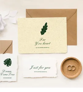 Plano detalle de tarjetas de felicitación minimalistas hechas a mano con estampados botánicos y sobres