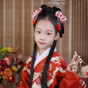 Close-up of young girl wearing traditional Chinese red bow hair clips with tassels and pom-poms