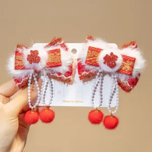Detailed view of traditional Chinese New Year red bow hair clips with pearl tassels