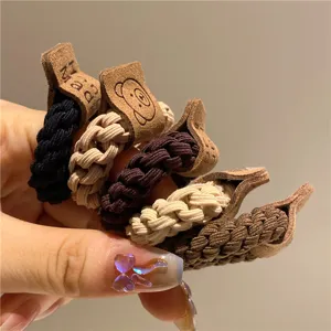 Primo piano di cinque elastici per capelli intrecciati con carini tag in pelle orso