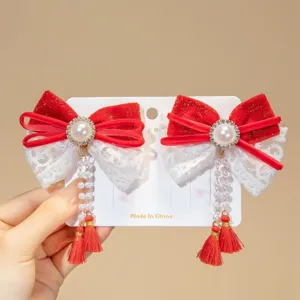 Close-up of Chinese style red velvet bow hair clips featuring pearls, lace, and long tassels