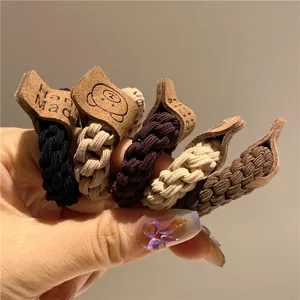 Dettaglio di elastici per capelli intrecciati spessi con simpatiche toppe a orsetto