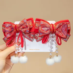 Detailed view of traditional Chinese red bow hair clips with pearl tassels