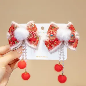 Close-up of red Chinese New Year hair clips with bows and poms