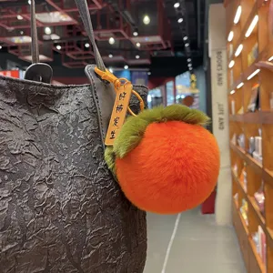 Creative cute persimmon-shaped Rex rabbit fur plush ball keychain hanging on black bag