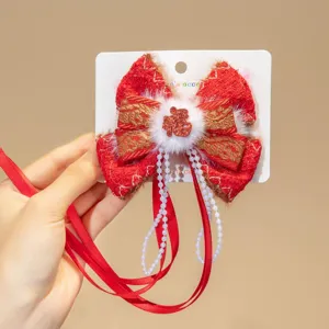 Close-up of Chinese New Year red bow hair clip with pearl tassel and Fu character