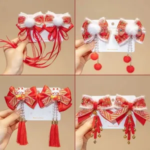 Festive Chinese New Year red bow hair clips with tassels and pom-poms for girls.