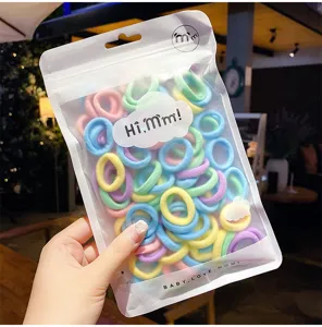 Gedetailleerde weergave van gekleurde macaron mini haarelastiekjes in een zakje