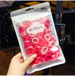 Gedetailleerde weergave van roze handdoek-haarelastiekjes in een matte verpakking