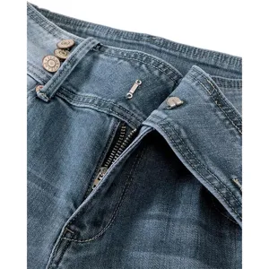 Close-up detail of women's denim jeans waistband, multi-button closure and classic blue wash.