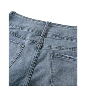 Close-up detail of women's grey blue denim jeans back waist and back pockets design.