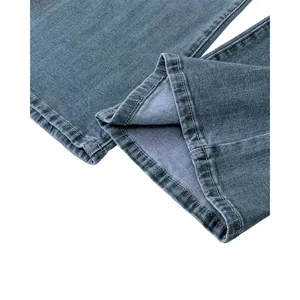 Detail view of blue denim jeans cuff showing neat stitching and classic fabric texture.