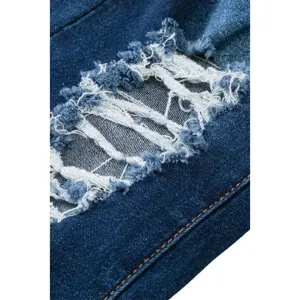 Detail view of distressed blue denim jeans showcasing raw frayed edges and neat stitching.