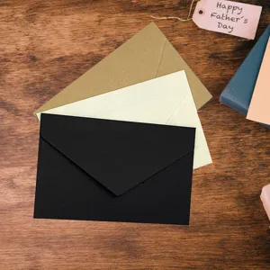 Primer plano de sobres vintage de papel grueso en colores negro, beige y marrón