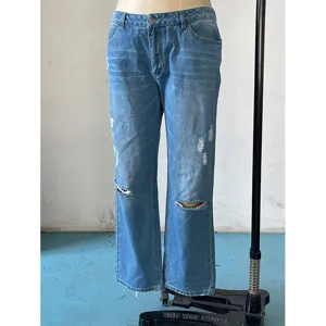Close-up detail of light blue distressed straight-leg denim jeans with ripped knees and mid-waist.
