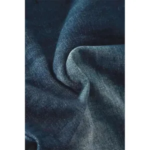 Close-up detail of dark blue denim fabric showing clear texture and washed gradient finish.