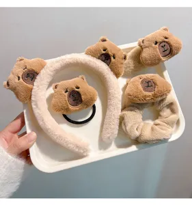 Detailed view of cute plush capybara headband, scrunchie and hair clips set