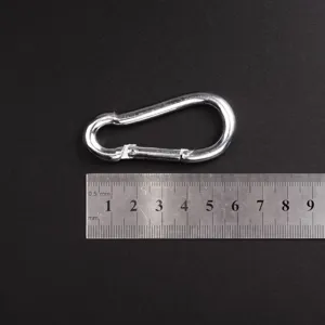 Détail de mousqueton en fer zingué avec règle métallique pour montrer la taille.