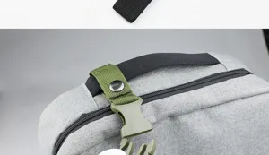 Detail view of a grey backpack with tactical green buckle and black webbing strap accessories.