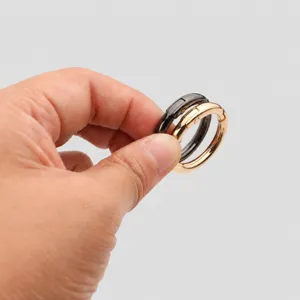 Gros plan de détail d'anneau à ressort en métal doré et noir mousqueton rond pour accessoires.