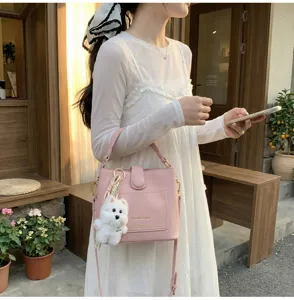 Sac seau rose à grain de litchi avec charmant pendentif chien en situation