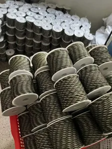 Detailed view of military green 7-core paracord spools, bulk warehouse stock display line.