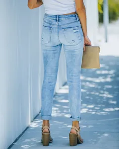 Detailed back view of light blue high-waisted distressed skinny jeans with rolled cuffs.