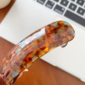 Detailed view of the acetate tortoiseshell pattern on an elegant women's hair clip.